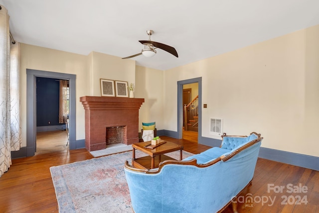 living room with hardwood / wood-style flooring, ceiling fan, plenty of natural light, and a fireplace