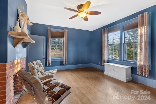 living area featuring ceiling fan, a healthy amount of sunlight, and wood-type flooring