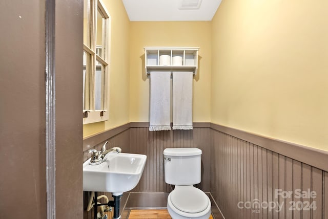 bathroom featuring hardwood / wood-style flooring, toilet, and sink