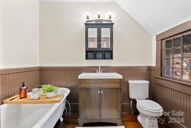 bathroom featuring a bathtub, vanity, vaulted ceiling, hardwood / wood-style flooring, and toilet