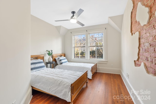 bedroom featuring ceiling fan, hardwood / wood-style floors, and vaulted ceiling