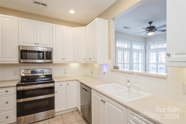 kitchen featuring backsplash, sink, white cabinets, and appliances with stainless steel finishes