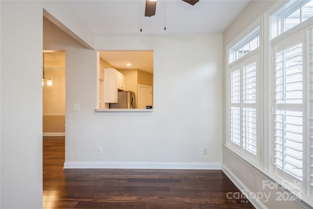 unfurnished room with ceiling fan and dark wood-type flooring