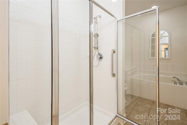 bathroom with toilet, shower with separate bathtub, and tile patterned floors