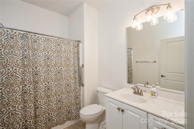 bathroom featuring tile patterned flooring, vanity, and toilet