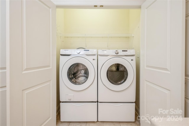 laundry area featuring washing machine and dryer and light tile patterned flooring