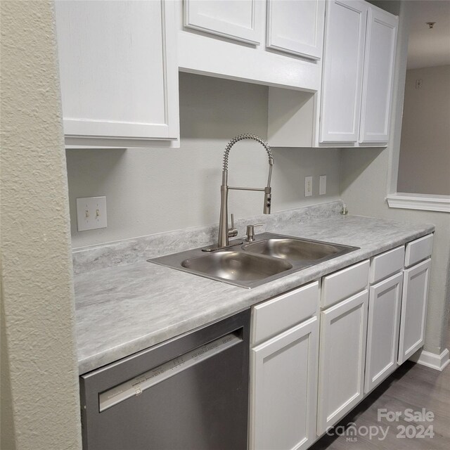 kitchen with dishwasher, white cabinets, dark hardwood / wood-style floors, and sink