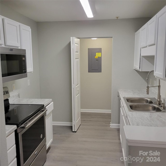 kitchen with white cabinetry, sink, stainless steel appliances, electric panel, and light hardwood / wood-style floors