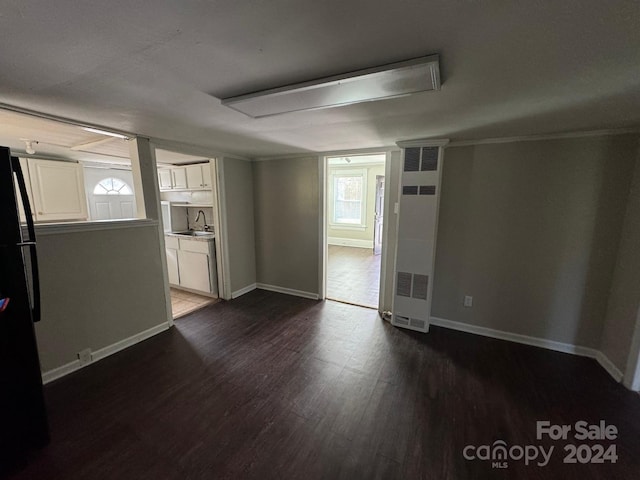 spare room with dark hardwood / wood-style flooring, crown molding, and sink