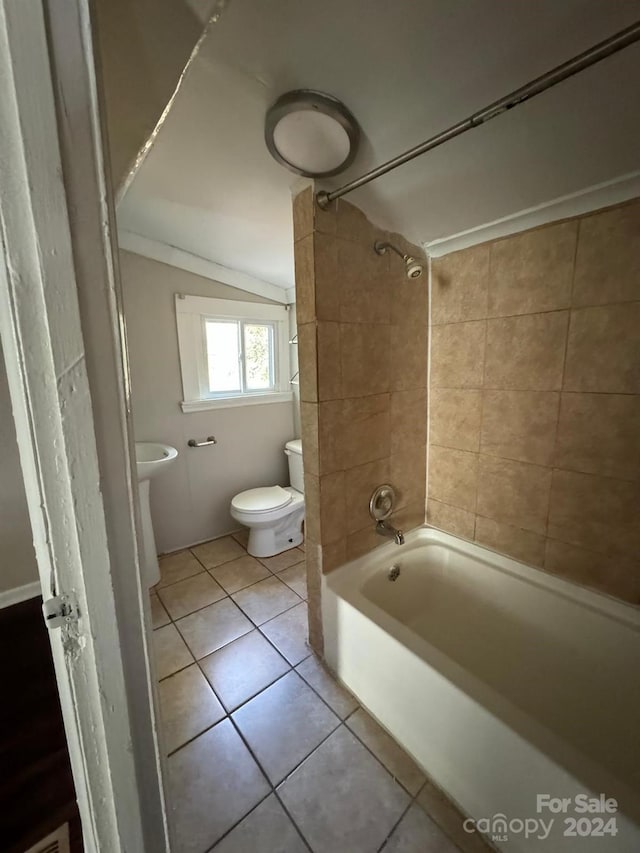 bathroom with toilet, tile patterned floors, and tiled shower / bath