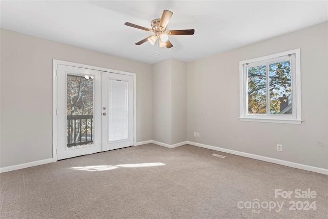 carpeted spare room with french doors and ceiling fan