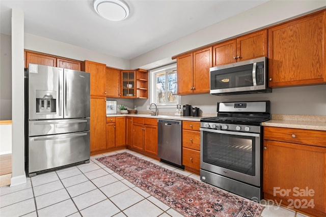 kitchen featuring light tile patterned floors, sink, and appliances with stainless steel finishes