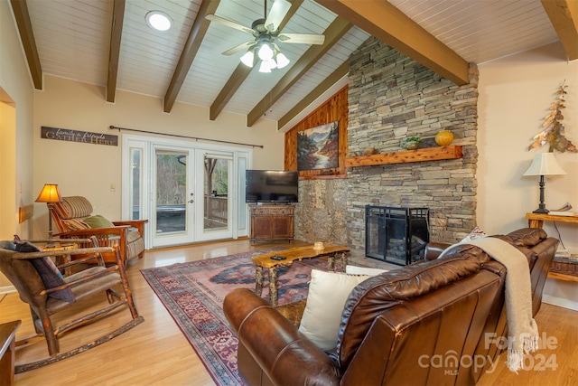 living room featuring hardwood / wood-style flooring, beam ceiling, a fireplace, and french doors