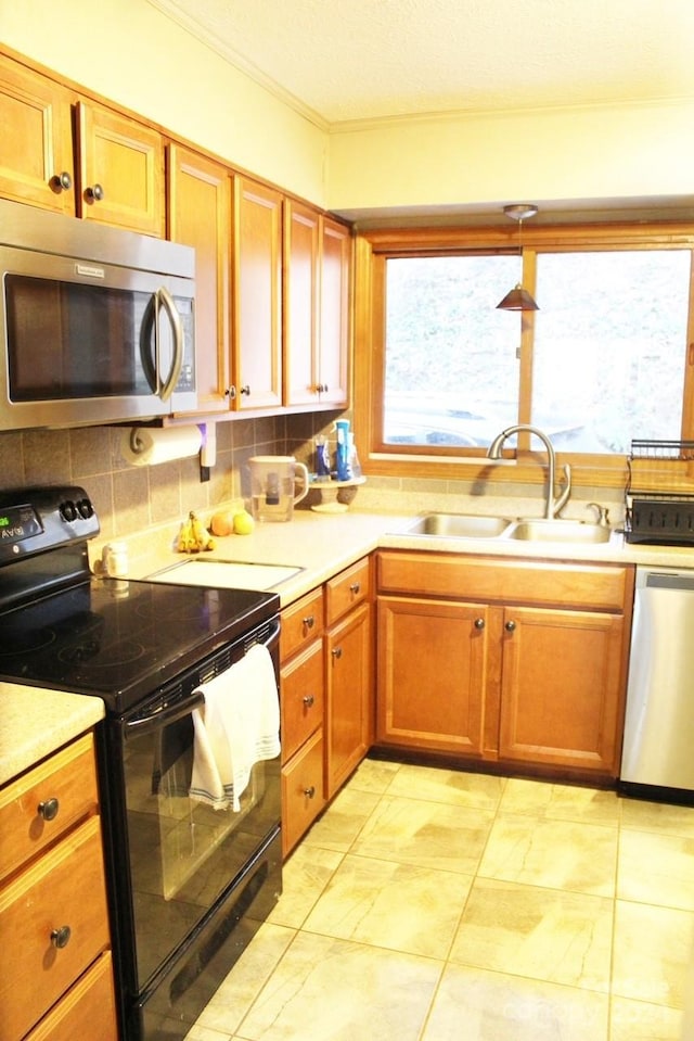 kitchen with hanging light fixtures, decorative backsplash, sink, and stainless steel appliances