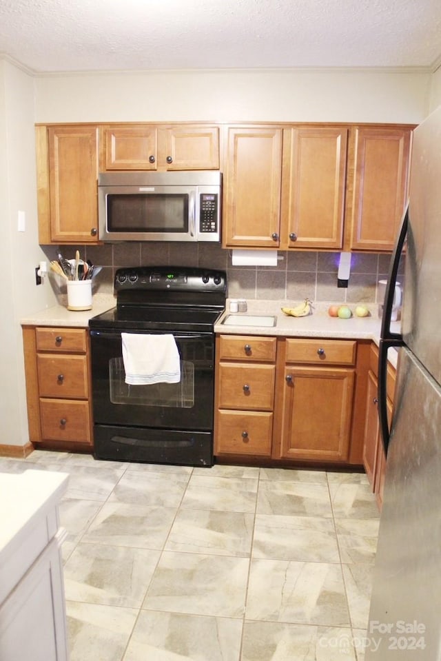 kitchen with decorative backsplash, a textured ceiling, and stainless steel appliances