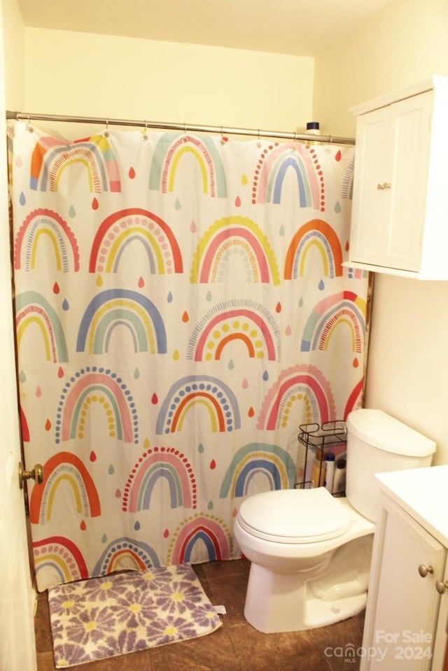 bathroom with tile patterned flooring, a shower with curtain, vanity, and toilet