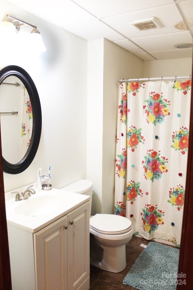 bathroom featuring tile patterned floors, a paneled ceiling, vanity, and toilet