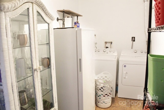 washroom featuring light tile patterned floors and washing machine and clothes dryer