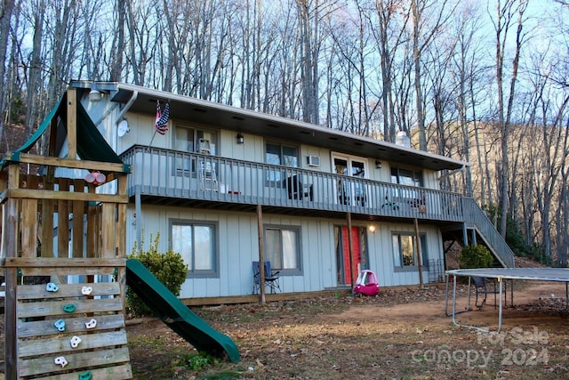 back of house with a trampoline