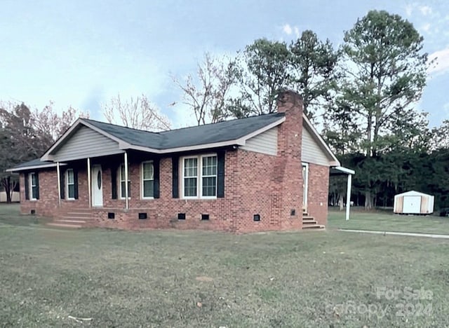 view of front of house featuring a porch, a storage shed, and a front lawn