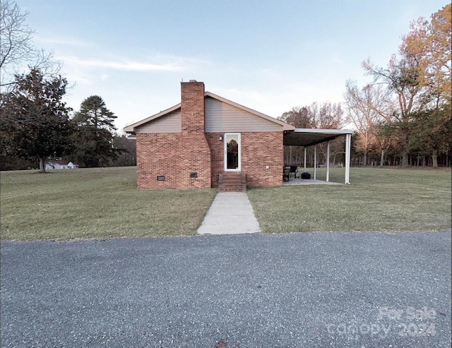 view of front facade with a carport and a front lawn