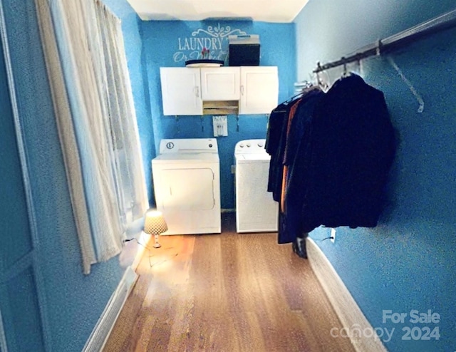 laundry room featuring hardwood / wood-style floors, cabinets, and washing machine and clothes dryer