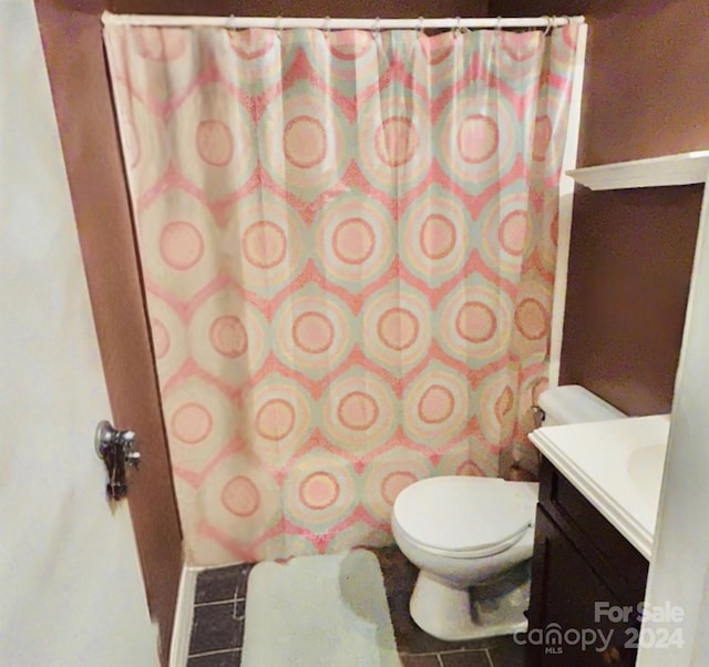 bathroom with tile patterned flooring, vanity, and toilet