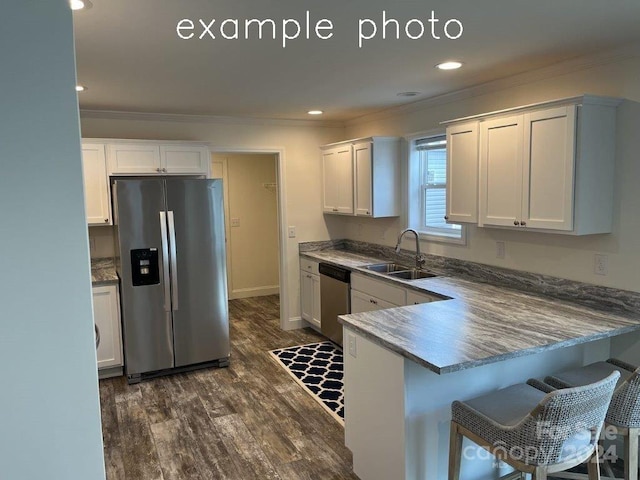 kitchen featuring dark wood-type flooring, sink, white cabinetry, kitchen peninsula, and stainless steel appliances