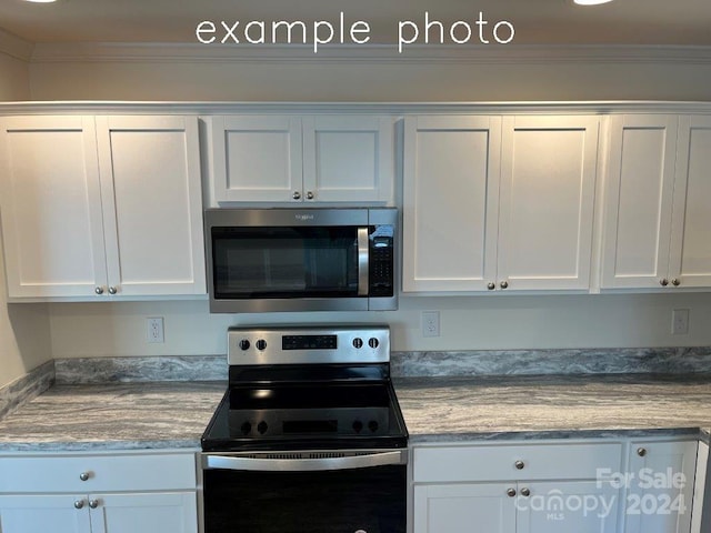 kitchen with crown molding, white cabinets, light stone countertops, and appliances with stainless steel finishes