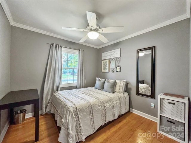 bedroom with ceiling fan, wood-type flooring, and crown molding