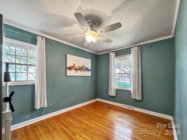 empty room with hardwood / wood-style flooring, ceiling fan, and ornamental molding