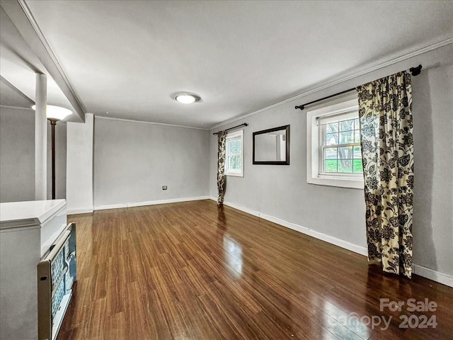 unfurnished living room with dark hardwood / wood-style floors and ornamental molding