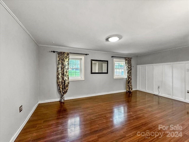 unfurnished room featuring ornamental molding, dark hardwood / wood-style flooring, and a healthy amount of sunlight