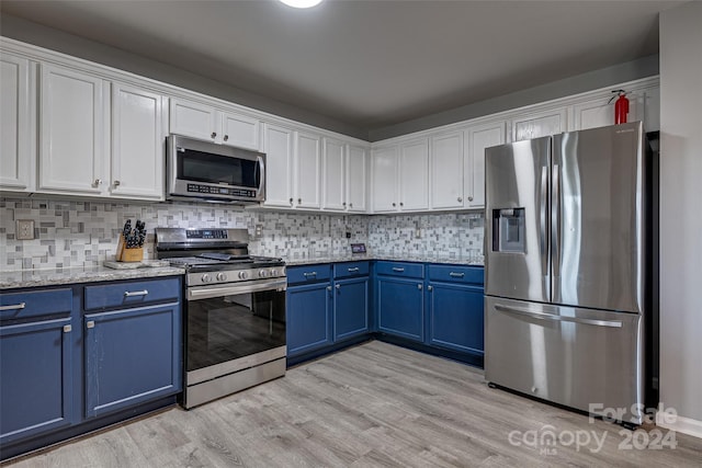 kitchen with white cabinets, light hardwood / wood-style floors, blue cabinets, and stainless steel appliances