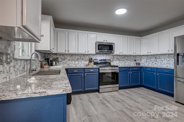 kitchen featuring white cabinetry, sink, blue cabinets, light hardwood / wood-style floors, and appliances with stainless steel finishes