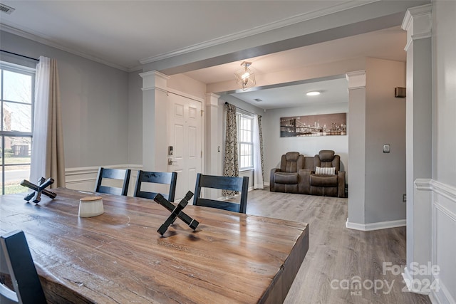 dining room featuring light hardwood / wood-style floors, a wealth of natural light, and crown molding