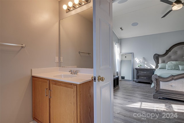 bathroom with hardwood / wood-style flooring, vanity, ceiling fan, and vaulted ceiling