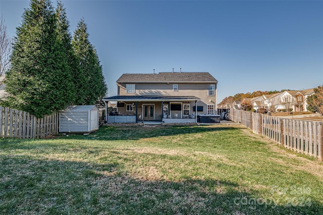 rear view of house featuring a lawn, a patio area, and a storage shed