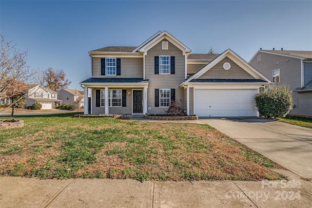 view of front of home with a front yard and a garage