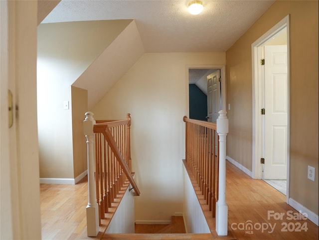 staircase with wood-type flooring and a textured ceiling