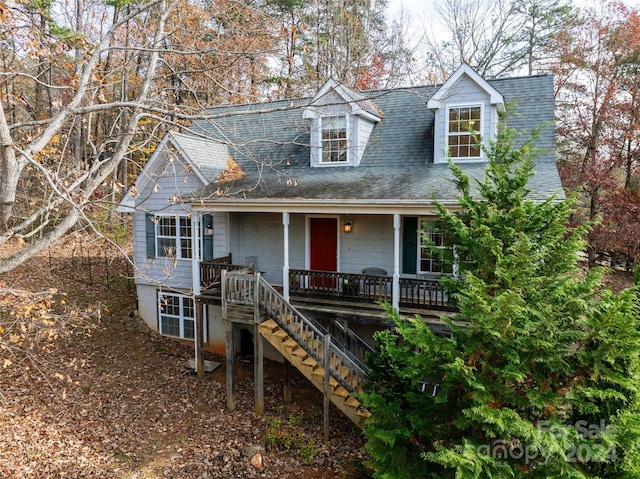 cape cod home featuring covered porch