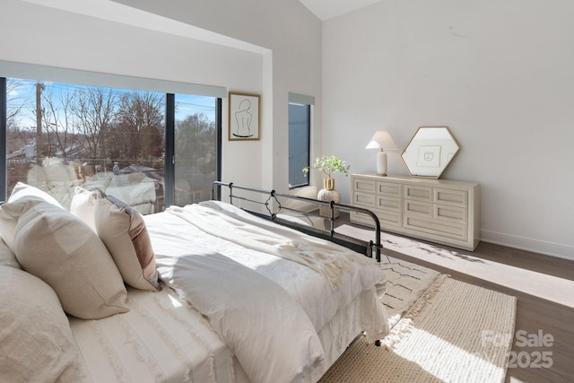 bedroom with hardwood / wood-style floors and lofted ceiling