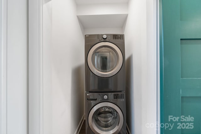 clothes washing area with stacked washing maching and dryer