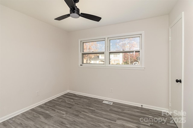 spare room featuring ceiling fan and dark wood-type flooring