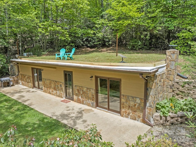 rear view of house with a lawn and a patio