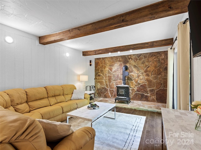 living room with a wood stove, wood walls, beamed ceiling, and hardwood / wood-style flooring