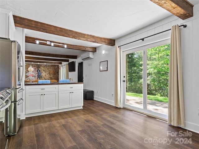 kitchen with stainless steel refrigerator, dark hardwood / wood-style flooring, beamed ceiling, a wall unit AC, and white cabinets