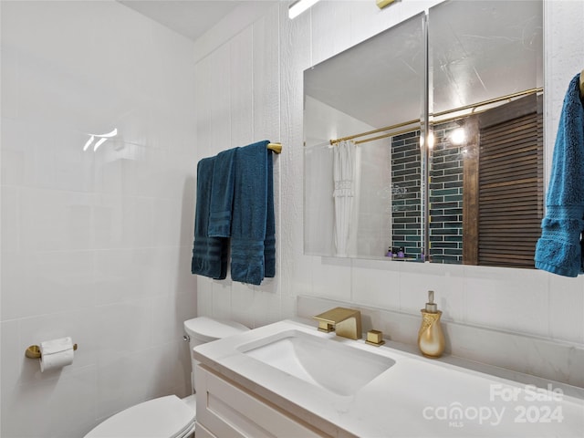 bathroom featuring a shower with curtain, vanity, toilet, and tile walls