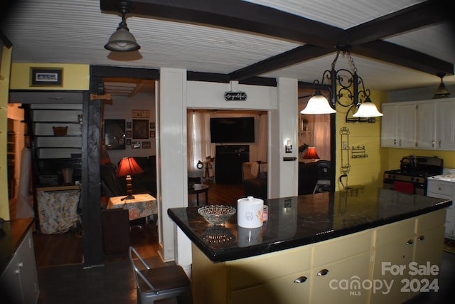 kitchen with an inviting chandelier, beamed ceiling, white range with gas stovetop, dark hardwood / wood-style floors, and a kitchen island