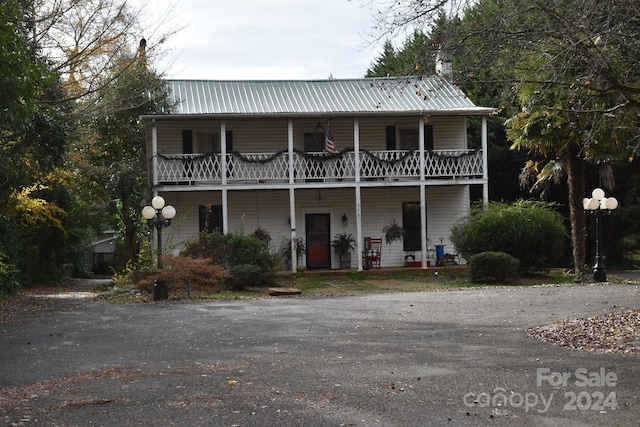306 Mcadenville Rd, Lowell, NC 28098 - view of front of house with a balcony and a metal roof